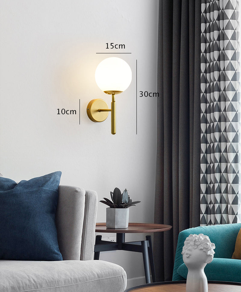 Applique murale LED verticale en forme de boule de verre laiteux avec luminaire en laiton brossé dans un style moderne du milieu du siècle