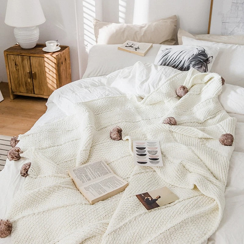 Grob gestrickte Chenille-Decke mit niedlichen Bommeln